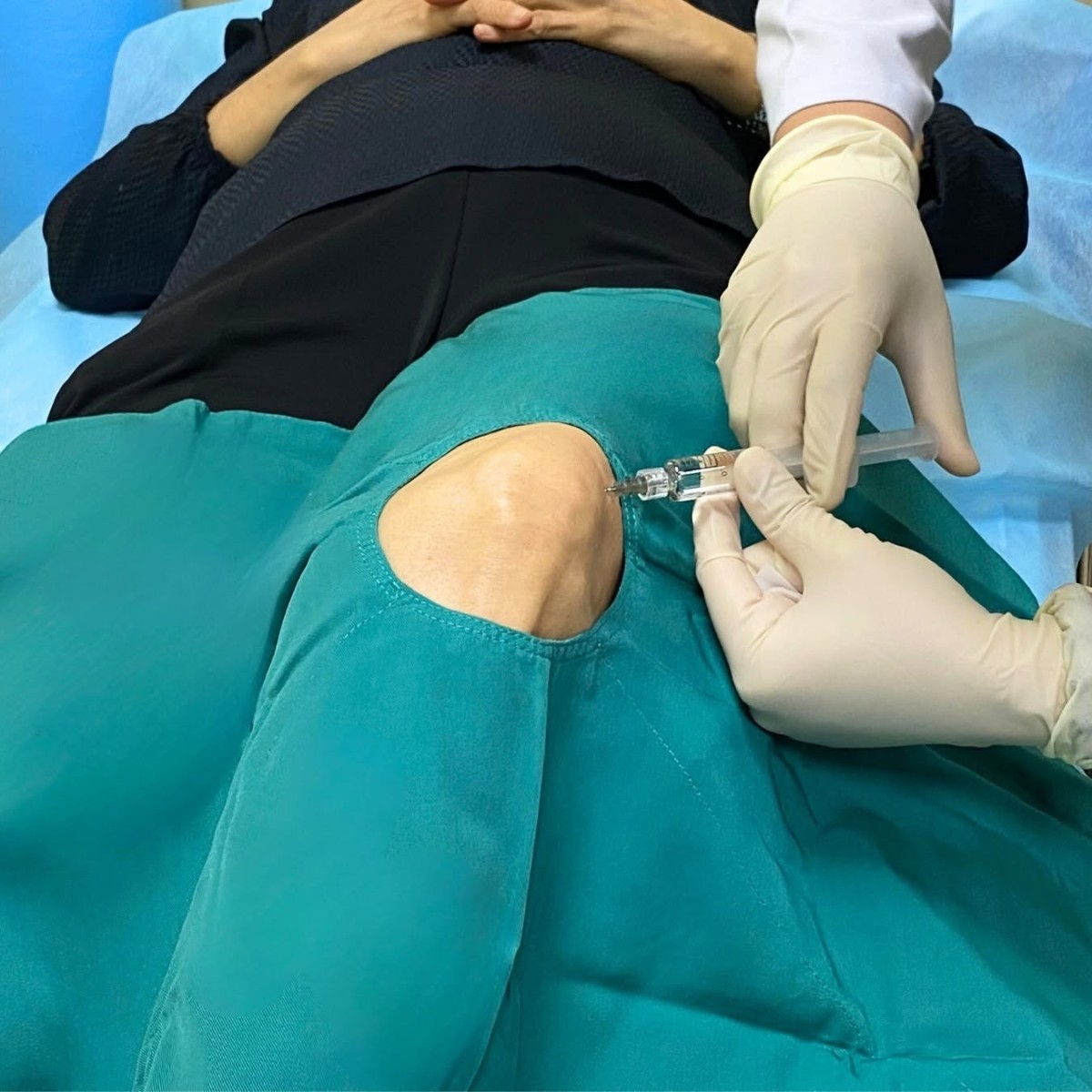 bác sĩ thực hiện tiêm thuốc vào khớp